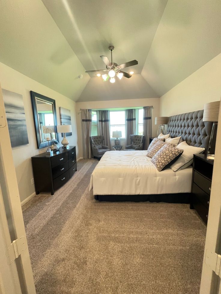 a bedroom with carpeted flooring and a bed in the middle of the room