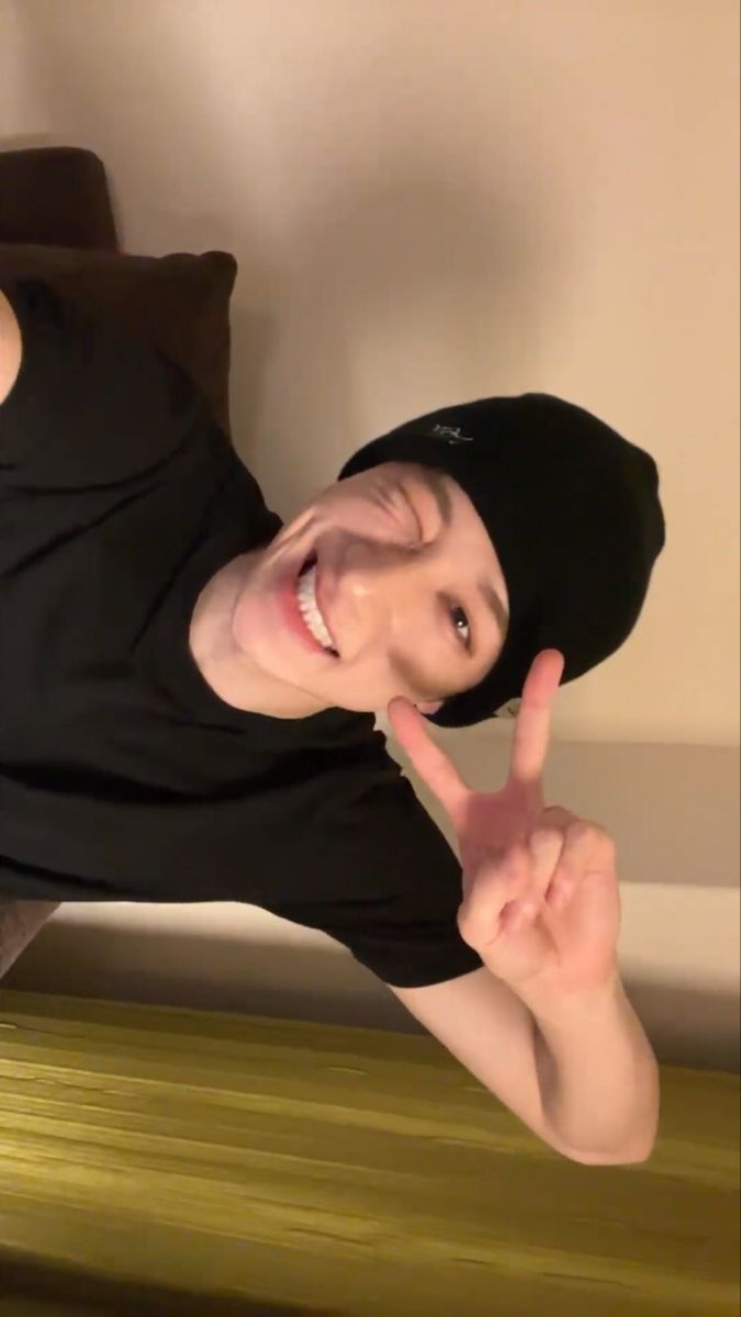 a young man making the peace sign with his fingers