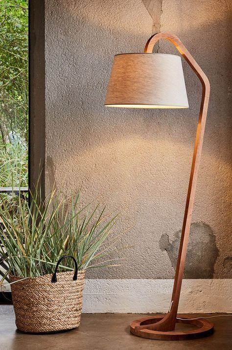 a floor lamp next to a potted plant