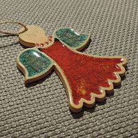 a red and green christmas ornament hanging from a keychain on a table