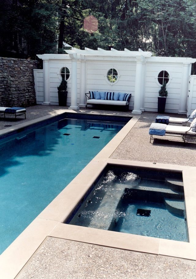 an empty swimming pool with chaise lounges next to it