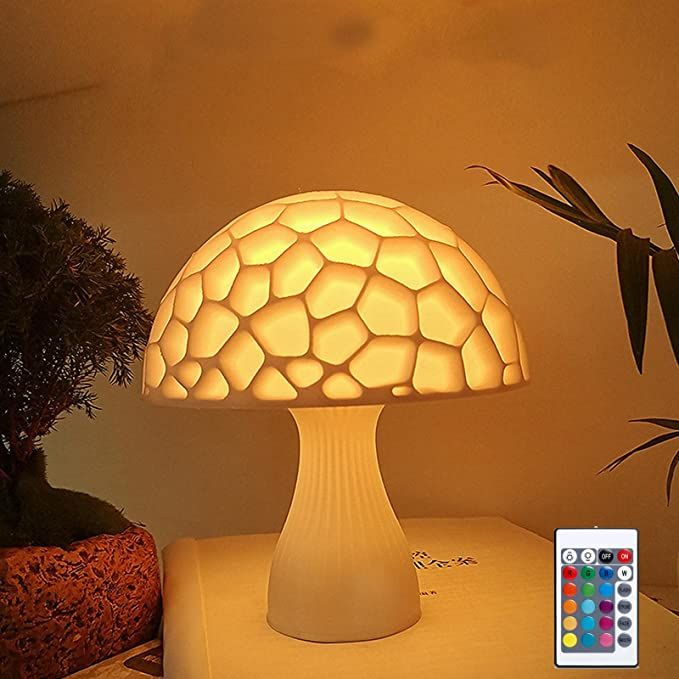 a mushroom shaped lamp sitting on top of a table next to a potted plant