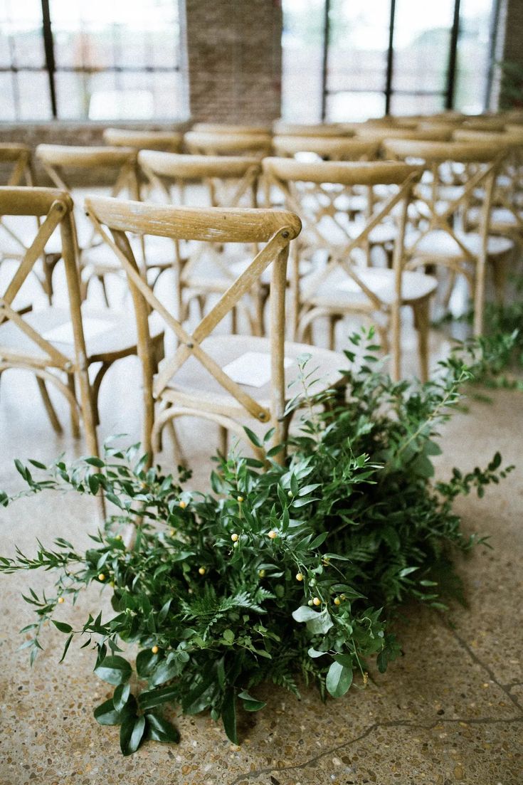 the chairs are lined up with greenery on them