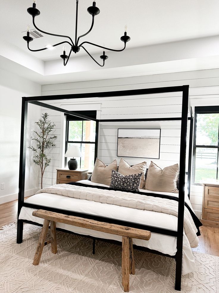 a four poster bed in a bedroom with white walls