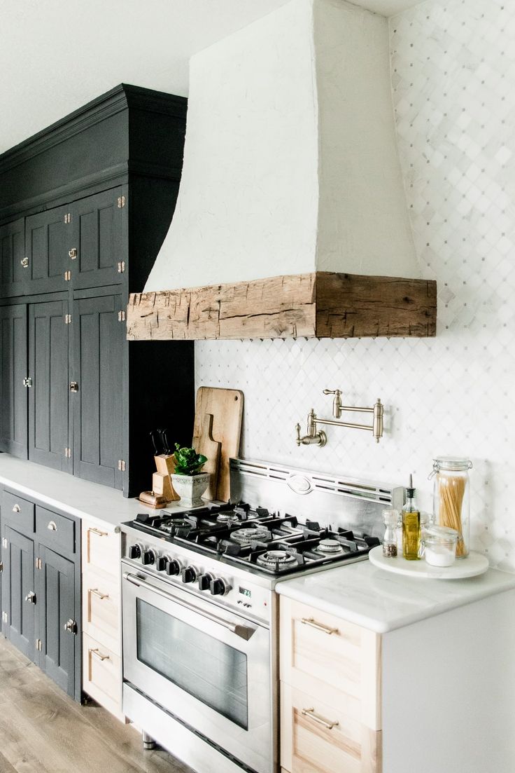 a stove top oven sitting inside of a kitchen next to a wall mounted range hood