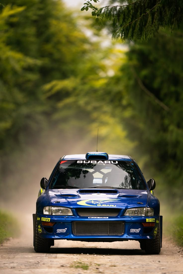 a blue car driving down a dirt road