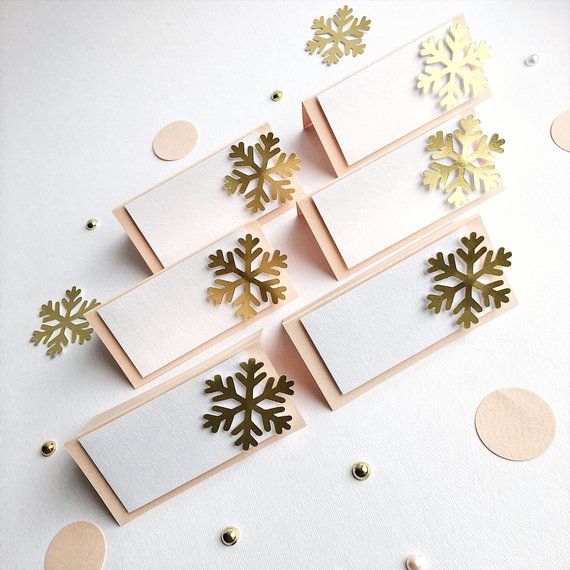 some cards with snowflakes on them and gold confetti around them,