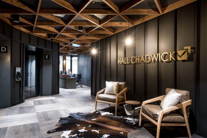 an office with black walls and wood accents