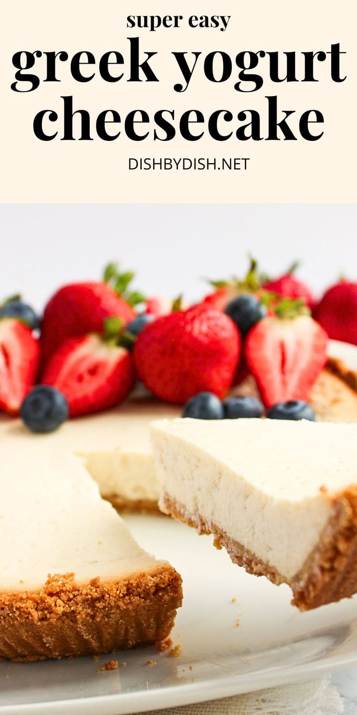 a cheesecake on a plate with strawberries and blueberries in the background text reads super easy greek yogurt cheesecake