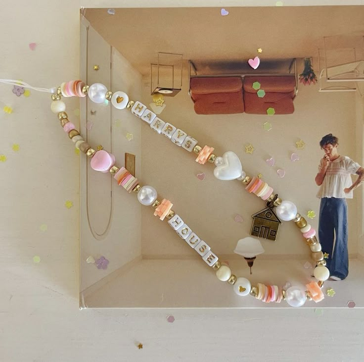 a man standing in front of a display case filled with beads and other things on the wall