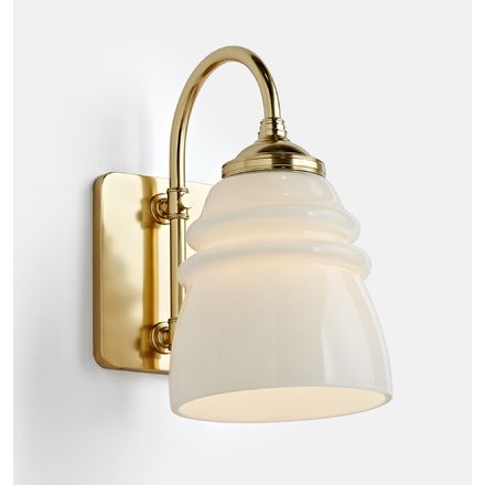 a wall light that is on the side of a wall with a white glass shade