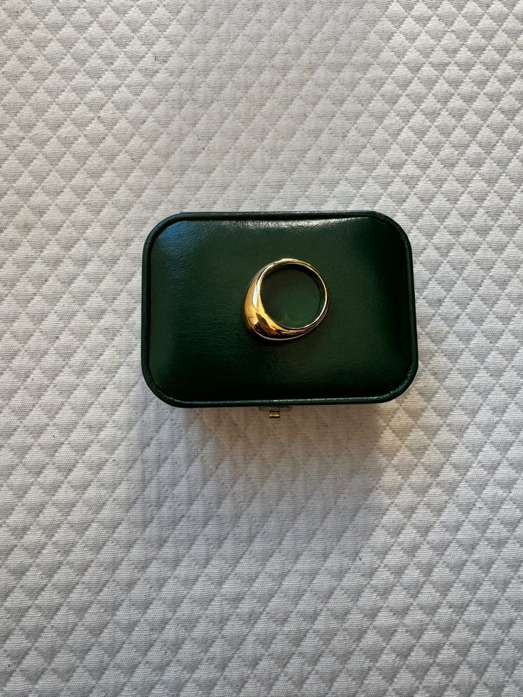 a green box with a gold ring on it