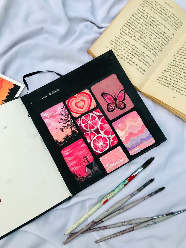 an open book and some art supplies on a bed