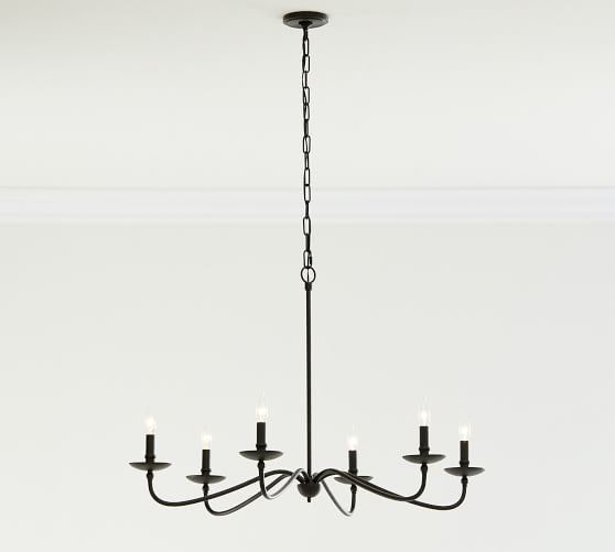 a black chandelier with five candles hanging from it's center, in a white room