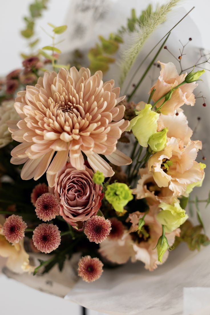 a bouquet of flowers sitting on top of a white countertop next to a wall