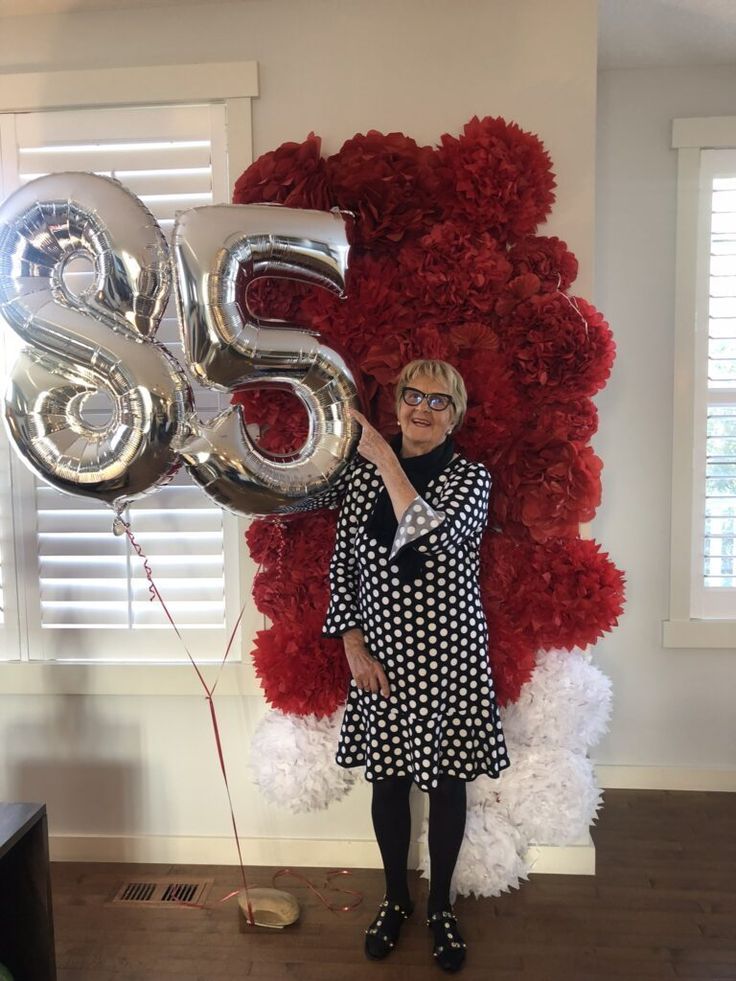 a woman standing in front of a giant balloon with the number twenty five on it