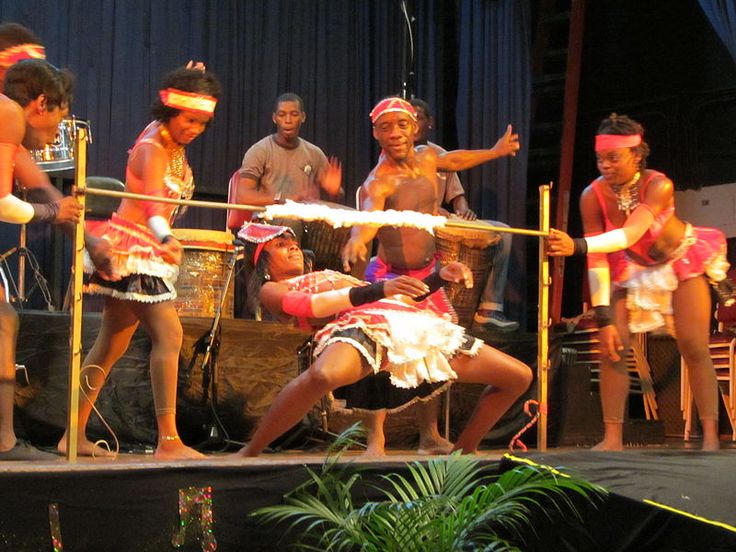 a group of people standing on top of a stage with one person holding a pole