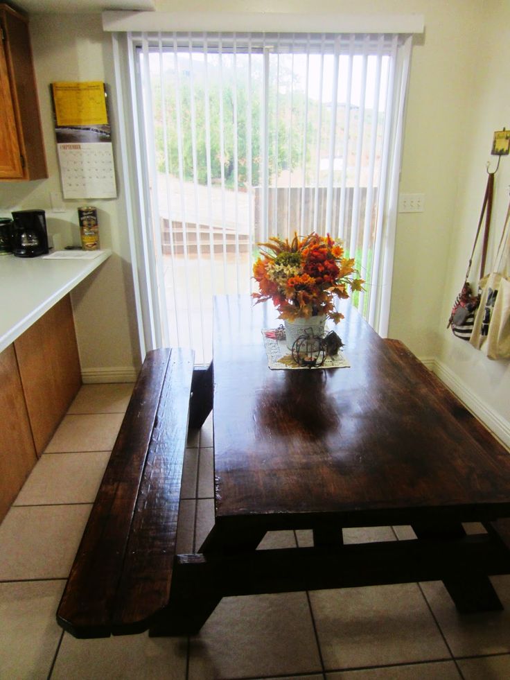 a wooden table sitting in front of a sliding glass door