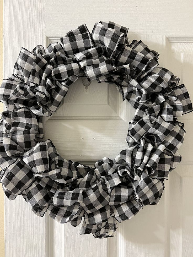 a black and white checkered wreath hanging on a door