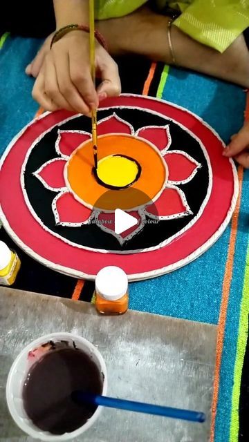 someone is painting a flower on a piece of paper