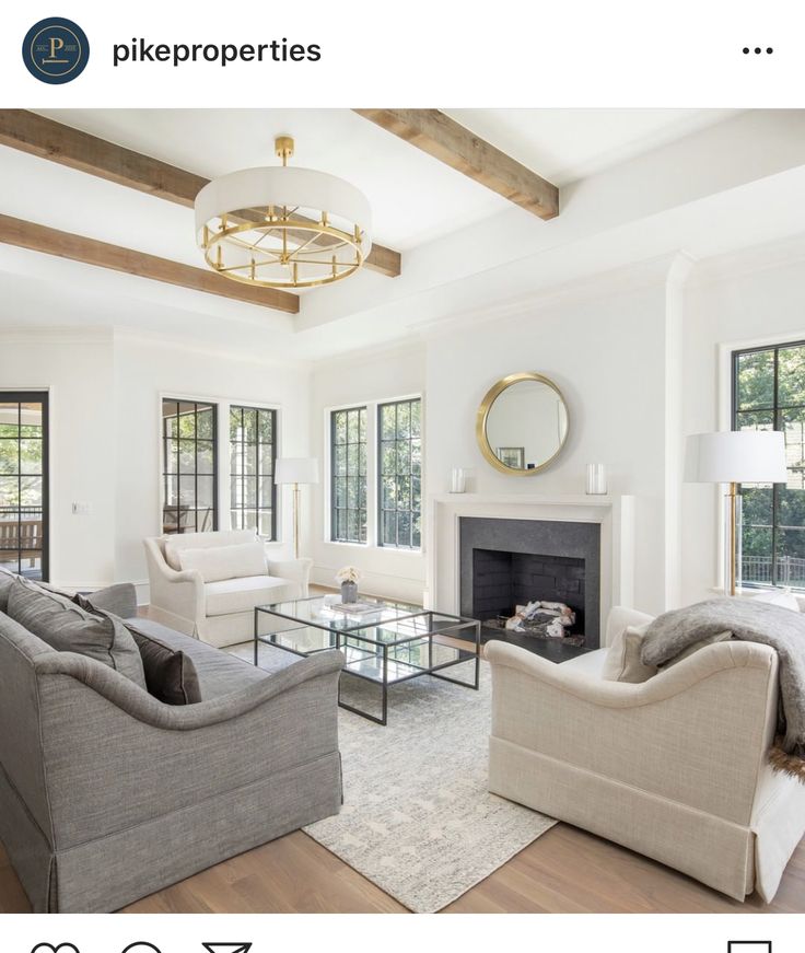 a living room filled with furniture and a fire place under a chandelier in front of a fireplace