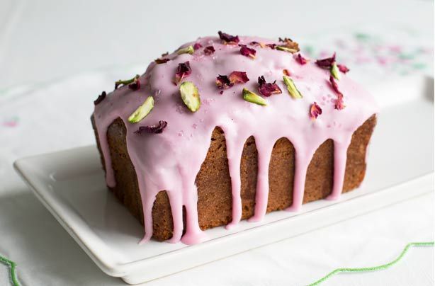 a bundt cake with pink icing and pistachio sprinkles