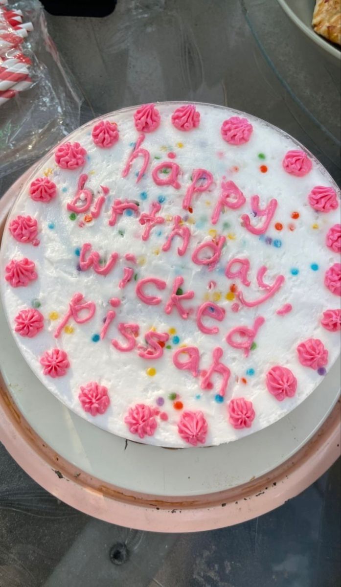 a birthday cake with pink frosting and sprinkles that says happy birthday