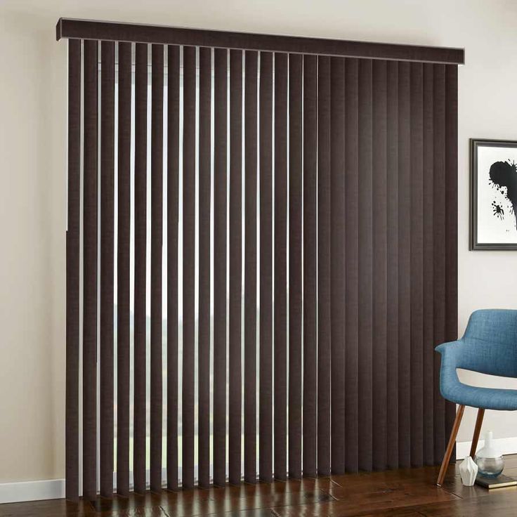 a living room with a blue chair and brown vertical blinds