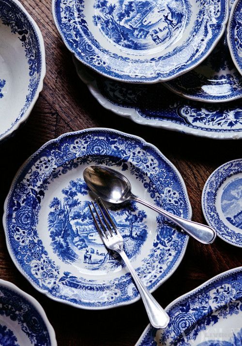 many blue and white plates with silverware on them