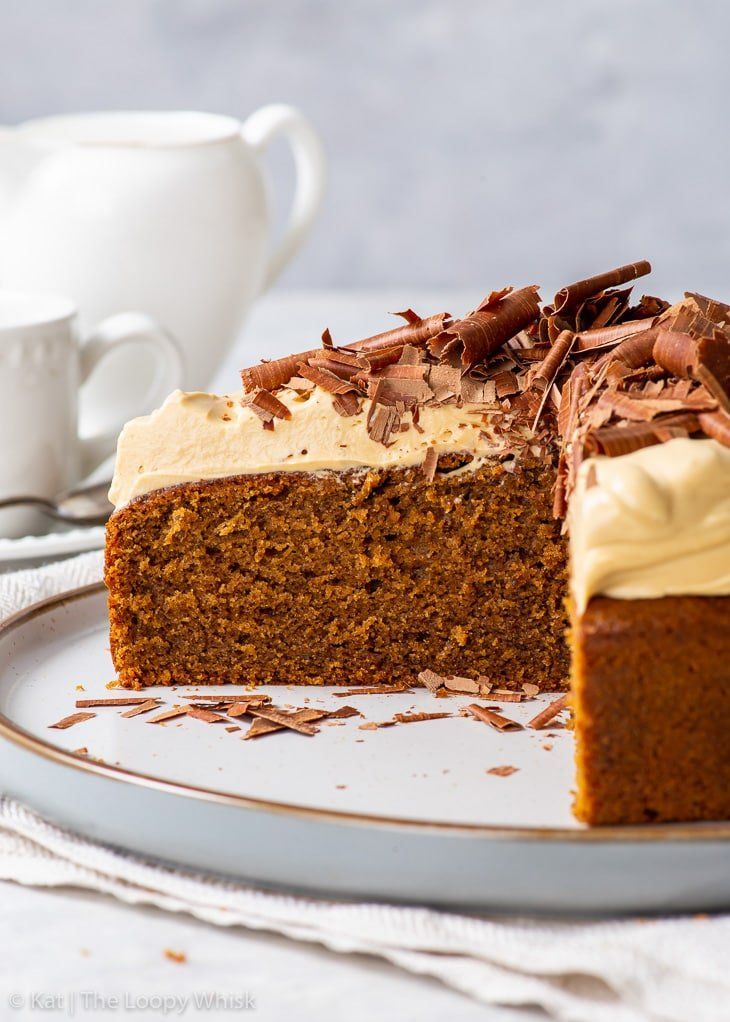 a slice of cake on a plate with a cup and saucer in the background