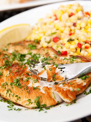 a white plate topped with fish and corn