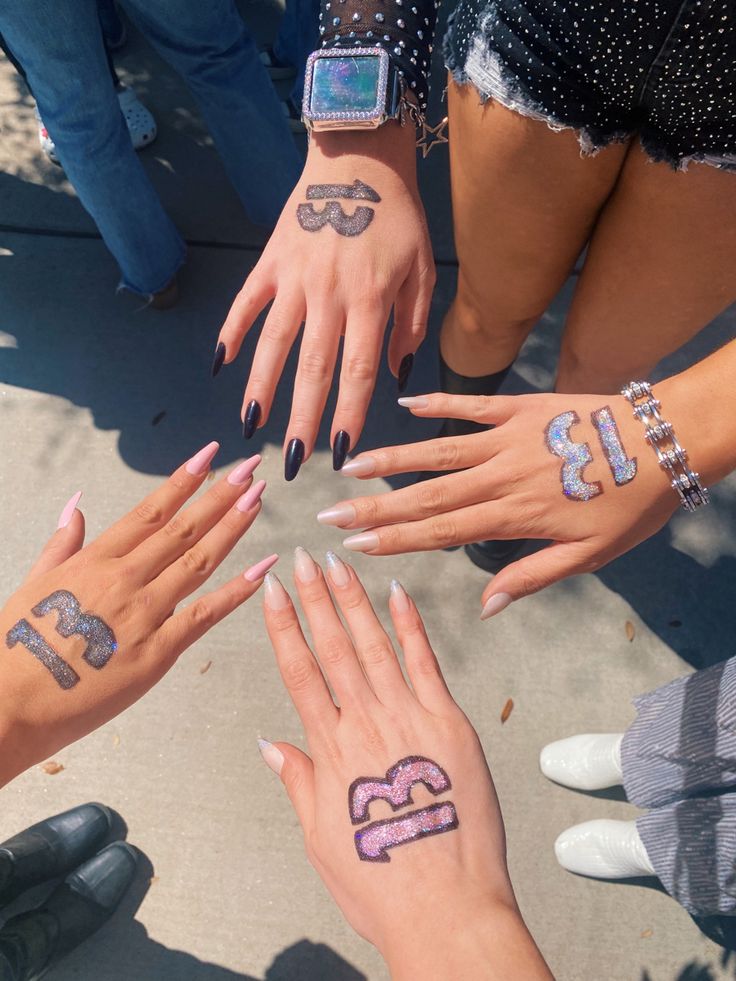 several people with numbers painted on their hands