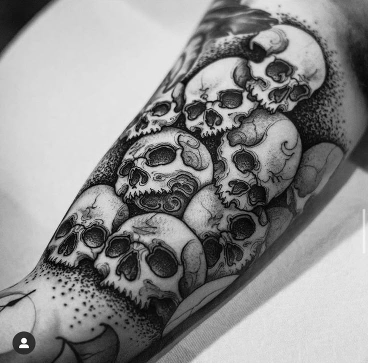 a man's arm with many skulls on it