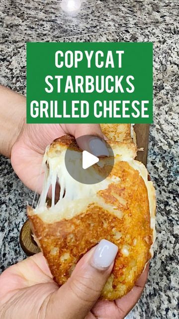 a person holding a piece of pizza in their hand with the caption copycat starbucks's grilled cheese