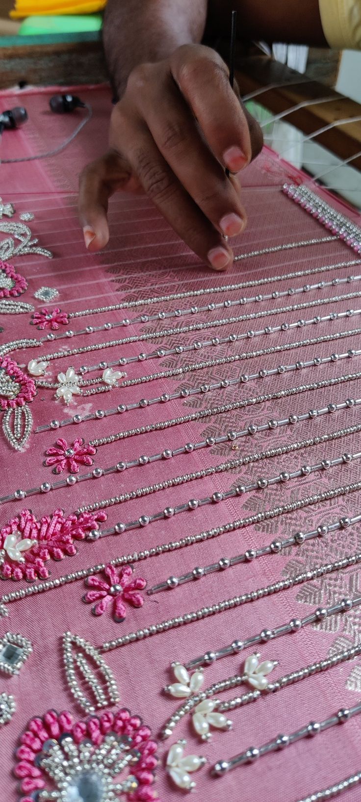 a woman is working on beading with beads