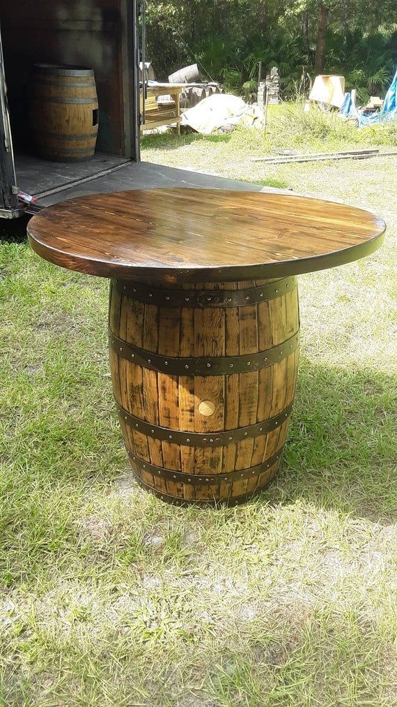 a wooden barrel table sitting in the grass