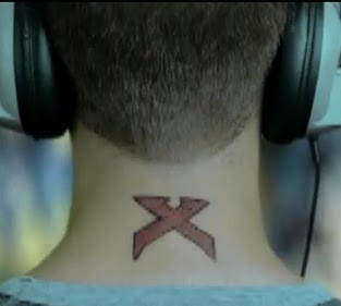 a man with headphones on his neck has a red x tattoo