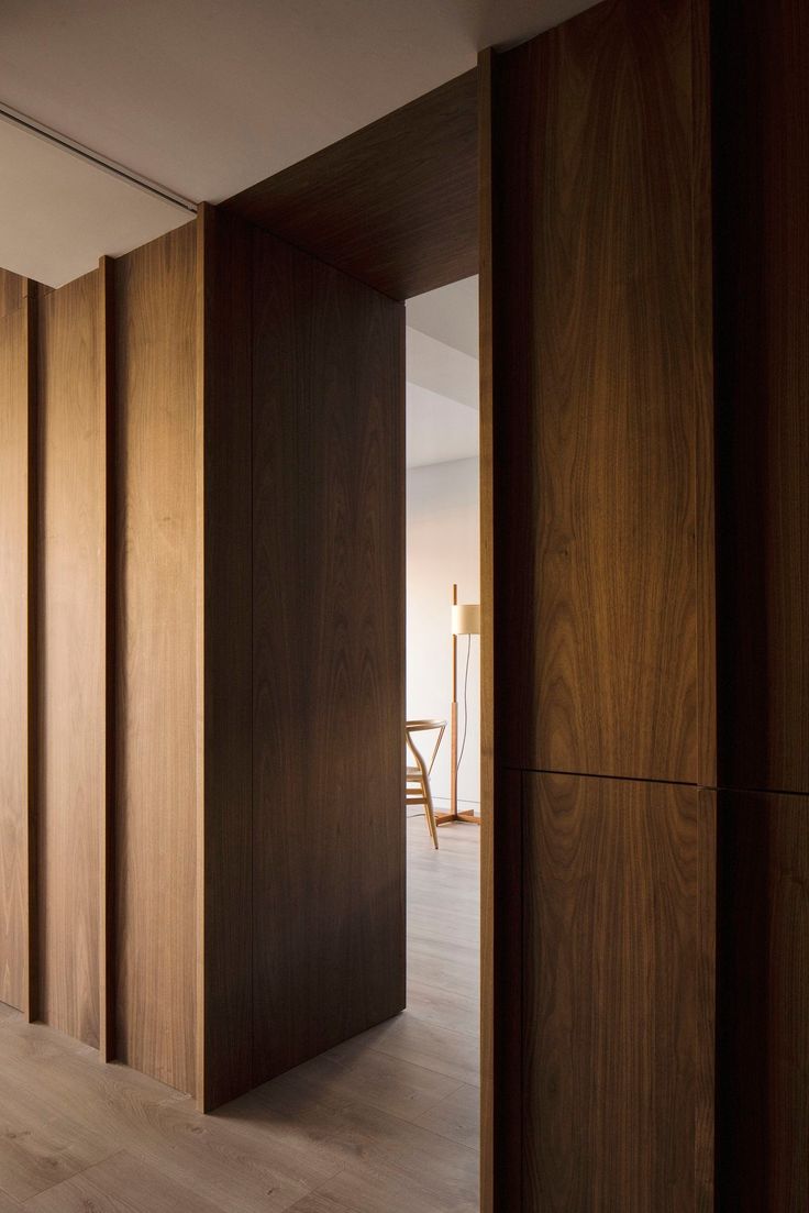 an open door leading into a room with wood paneling on the walls and floor