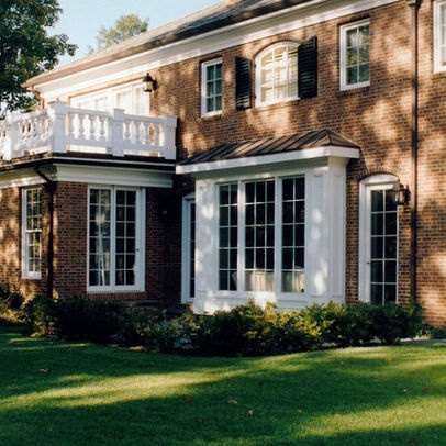 a large brick house with white windows and balconies