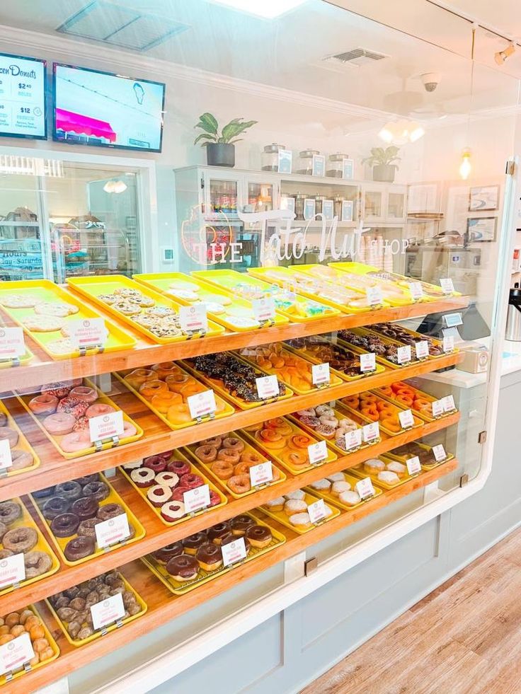 there are many different types of donuts in the display case at this bakery shop