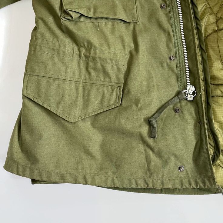 The most legendary and timeless jacket of all time, the M-65 Field Jacket has been loved by US Army, USAF, SEABEES, Special Forces and civilians all over the world. This original deadstock United States M-65 field jacket comes complete with an original filed jacket liner, concealable hood and a water-resistant outer shell. The family of olive green field jackets is a classic of military fashion. They are warm, rugged, functional and look great. Original G.I. jackets are getting hard to obtain, a Timeless Jacket, M65 Field Jacket, Green Field, Field Jacket, Baseball Jacket, Phoenix Az, Us Army, Military Fashion, Piece Of Clothing