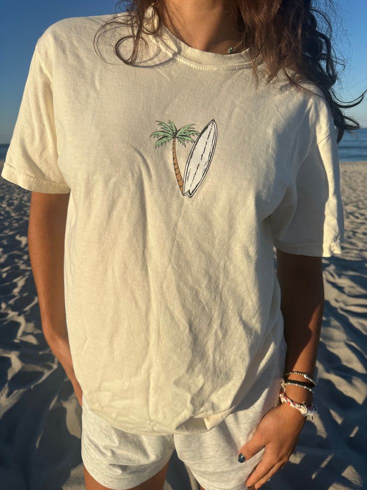 Introducing our Surfboard Tee, made from 100% ringspun cotton for optimal softness. The preshrunk, garment-dyed fabric is both durable and comfortable, perfect for a day at the beach or a casual hangout. With twill taped shoulders, set-in sleeves, and a ribbed collar, this tee is comparable to comfort colors and sure to be a favorite! 100% ringspun cotton * Preshrunk, soft-washed, garment-dyed fabric * Twill taped shoulder-to-shoulder * Set-in sleeves * Double-needle stitched sleeves and bottom Casual Cotton Tops For Beach Season, Soft-washed Cotton T-shirt For Summer, Short Sleeve Cotton T-shirt For Surfing, Cotton Short Sleeve T-shirt For Surfing, Cotton Short Sleeve Surfing T-shirt, Casual Washed T-shirt For Summer, Summer Cotton T-shirt For Surfing, Graphic Tee Cotton T-shirt For Vacation, Beachy Cotton T-shirt With Short Sleeves