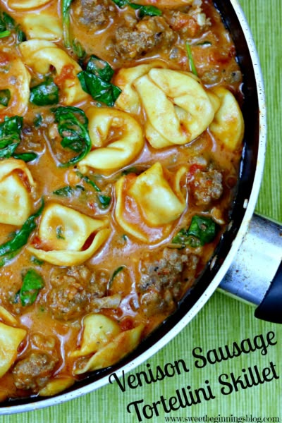 a skillet filled with tortelli shells and sauce on top of a green table