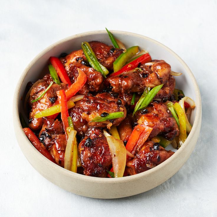 a white bowl filled with meat and vegetables