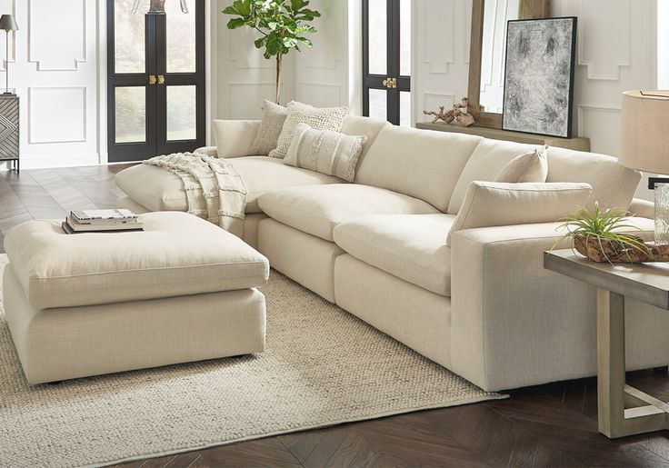 a living room filled with furniture and a large white couch in front of a window