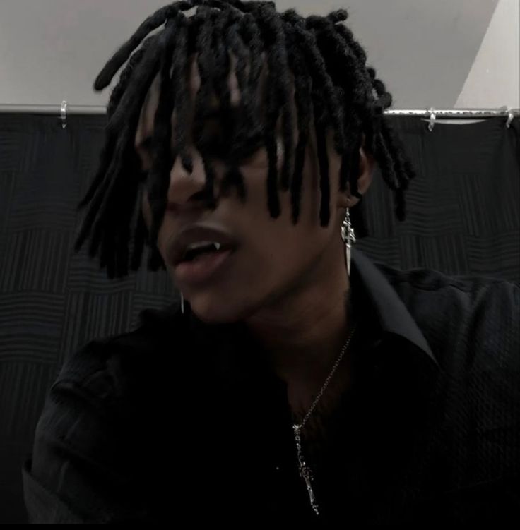 a man with dreadlocks sitting in front of a laptop computer