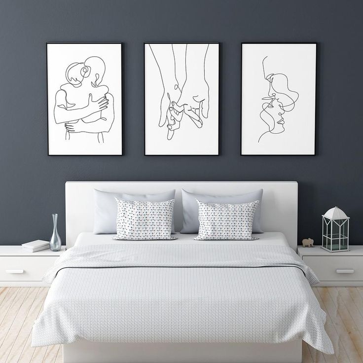 three black and white drawings hang above a bed