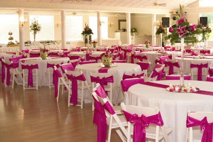 tables and chairs covered with pink sashes in a banquet hall