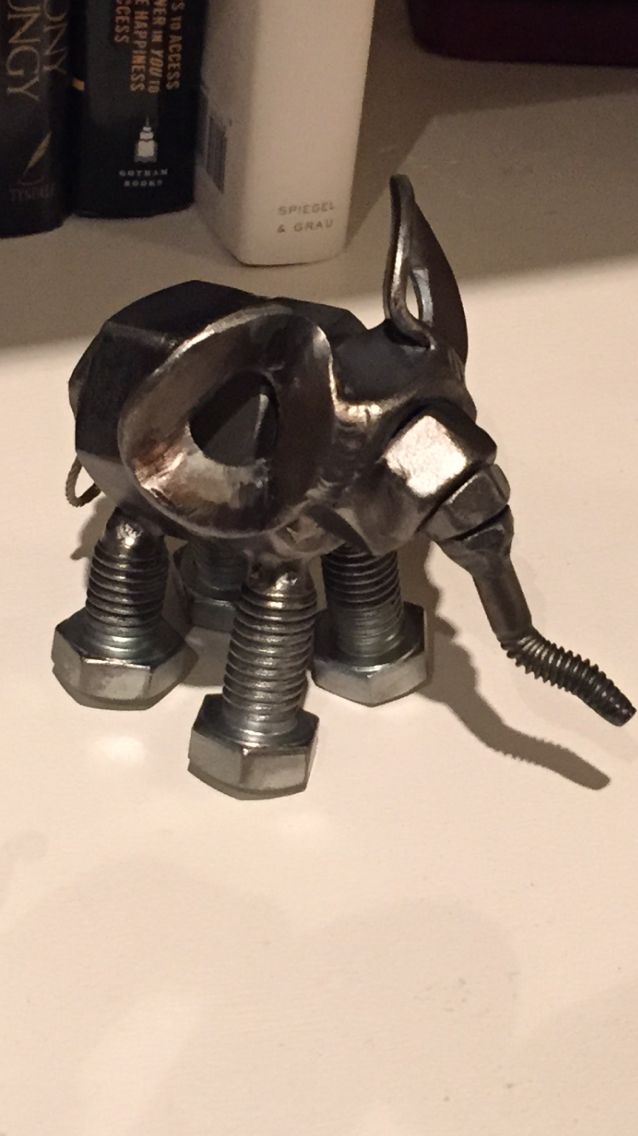 a metal object sitting on top of a table next to some books and a bottle opener