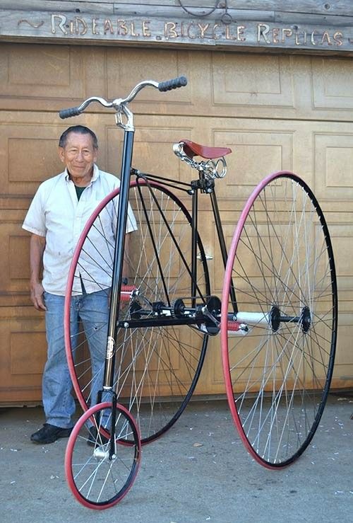 a man standing next to a red and black bike in front of a garage door